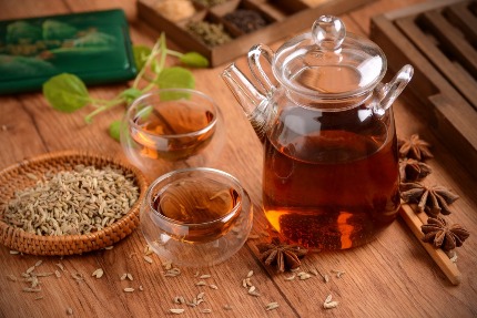 В чайнике заварен полезный чай, рядом лежат звездочки и семена аниса.