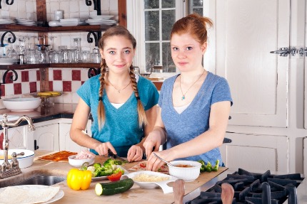 Девочки-подростки готовят еду.