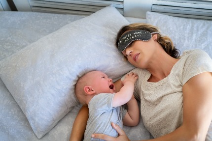 Уставшая мама уснула рядом с плачущим младенцем.