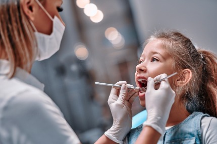 Стоматолог осматривает зубы ребенка