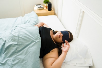 Полная женщина спит в маске