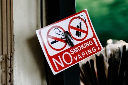 Табличка с надписью, запрещающей курить сигареты и вейпы