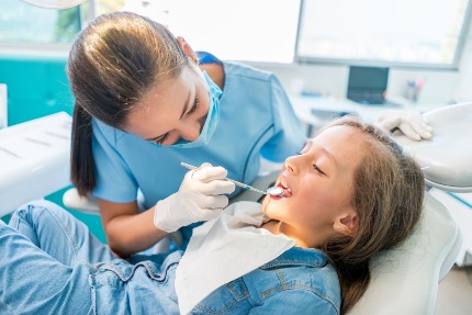 Девочка на осмотре у стоматолога.