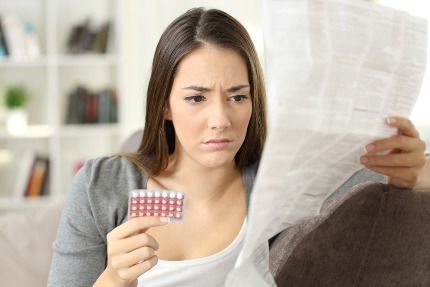Женщина читает инструкцию к гормональным контрацептивам.