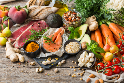 На столе лежат продукты, которые входят в средиземноморскую диету: рыба, овощи, орехи