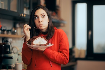 Женщина ест десерт из большой тарелки