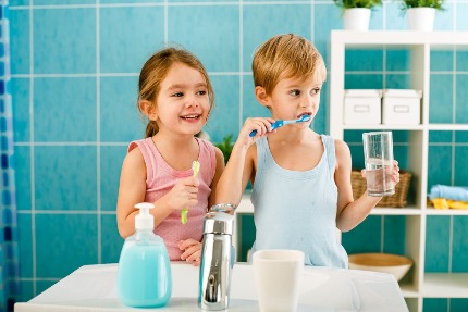 Мальчик и девочка чистят зубы