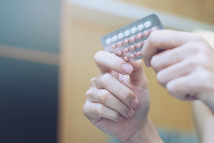 Женщина держит в руках блистер с оральными контрацептивами
