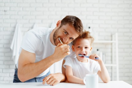 Папа и сын чистят зубы.