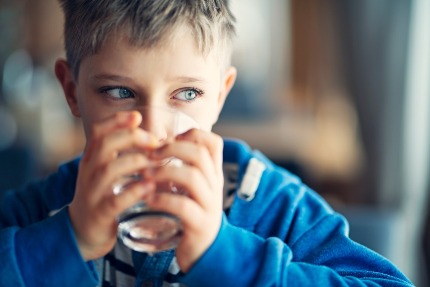 Мальчик пьет воду из стакана