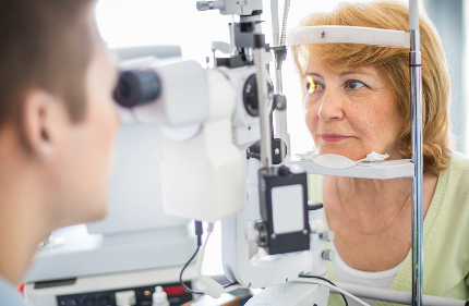 Женщина проходит проверку зрения у офтальмолога.
