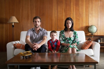 Мама, папа и ребенок сидят на диване